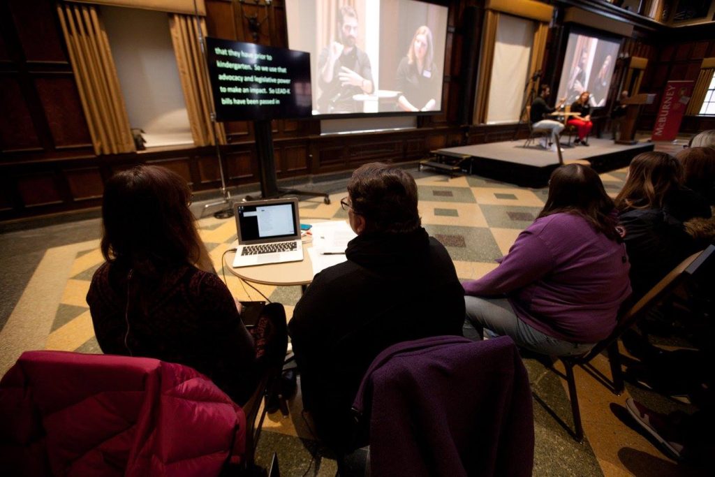 Professional CART Captioning is displayed as Nyle DiMarco signs to a large audience in conjunction with a Distinguished Lecture Series event at UW-Madison