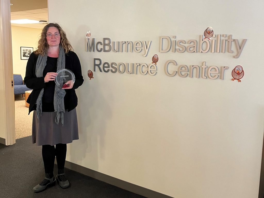 Maria Dahman posing with her access award at the McBurney Disability Resource Center