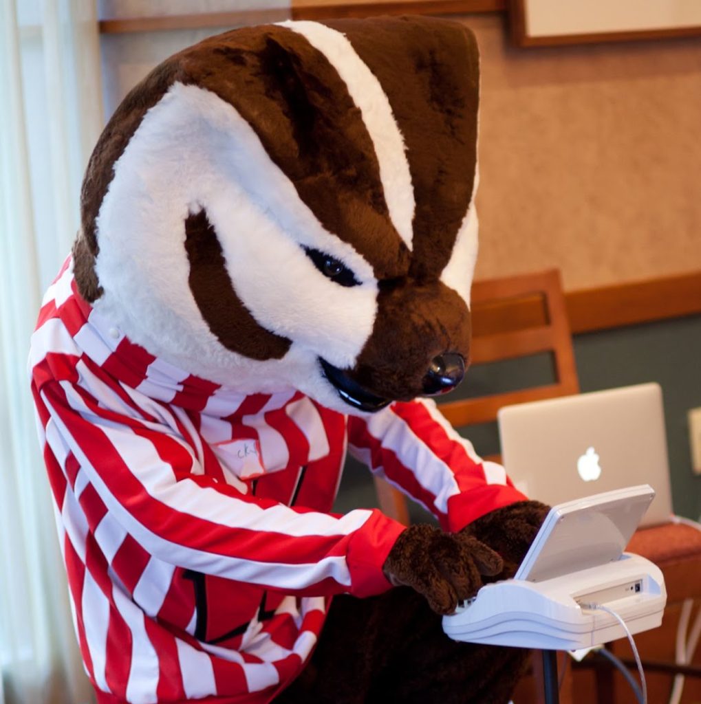 Bucky Badger using a stenography machine to make captioning.